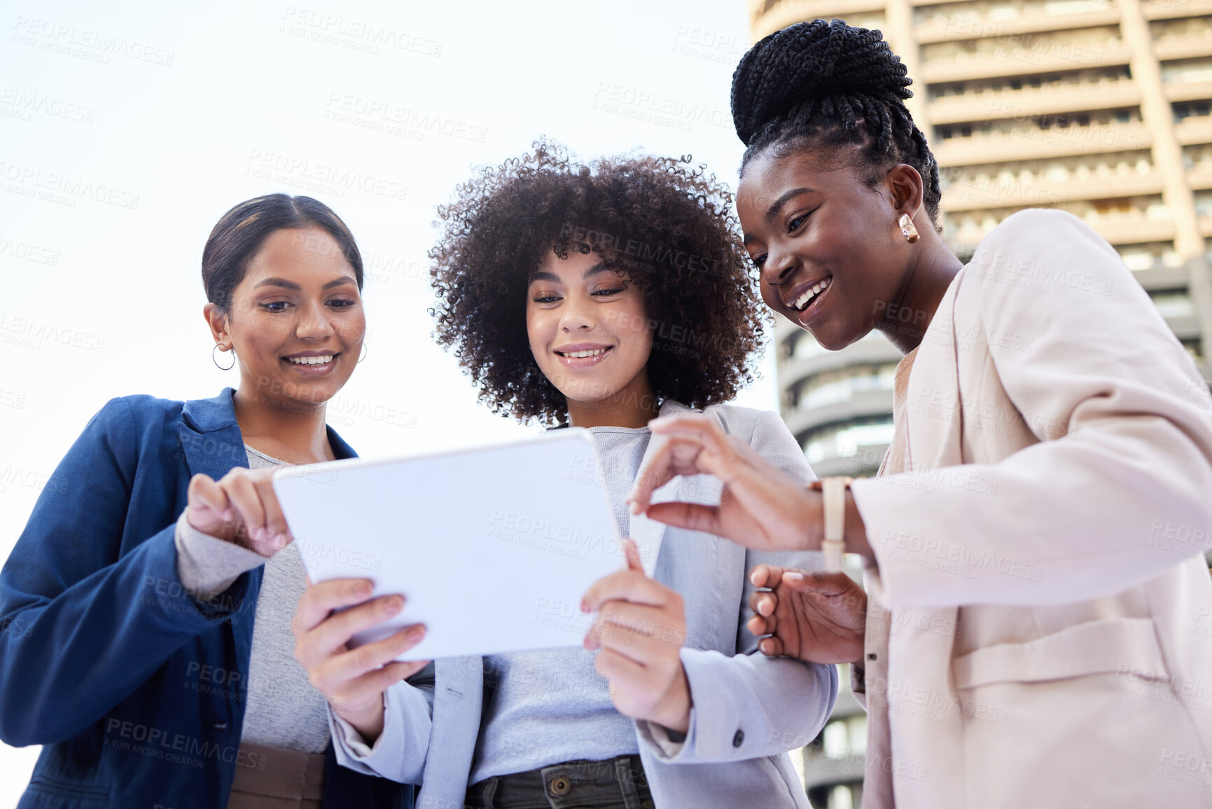 Buy stock photo Low angle shot of a diverse group of businesswomen standing outside on the balcony and using a digital tablet