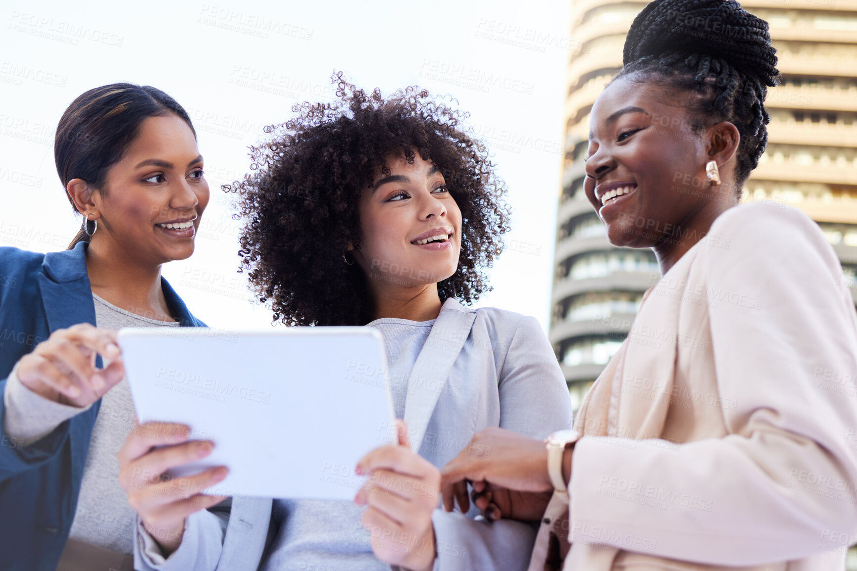 Buy stock photo Low angle shot of a diverse group of businesswomen standing outside on the balcony and using a digital tablet