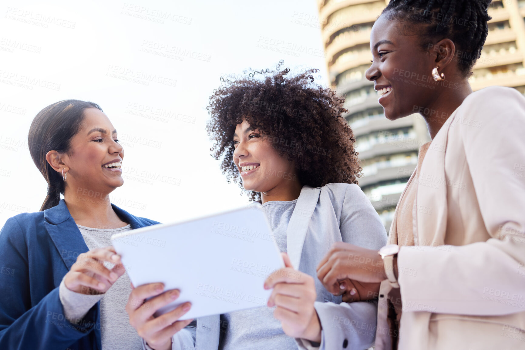 Buy stock photo Shot of a diverse group of businesswomen standing outside on the balcony and using a digital tablet