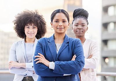 Buy stock photo Shot of a diverse group of businesswomen standing outside on the balcony with their arms folded