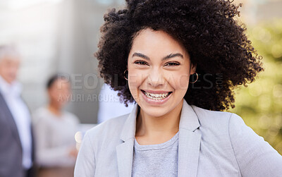 Buy stock photo Shot of an attractive young businesswoman standing outside while her colleagues stand behind her