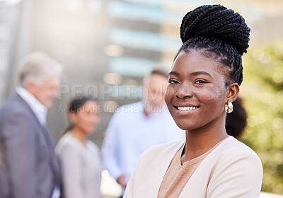 Buy stock photo Shot of an attractive young businesswoman standing outside while her colleagues stand behind her