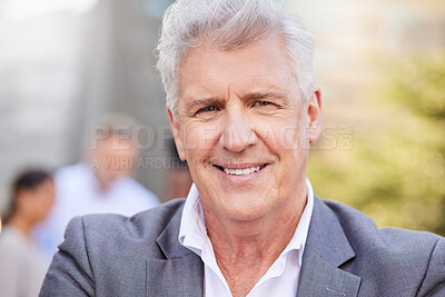 Buy stock photo Shot of a mature businessman standing outside while his colleagues stand behind him