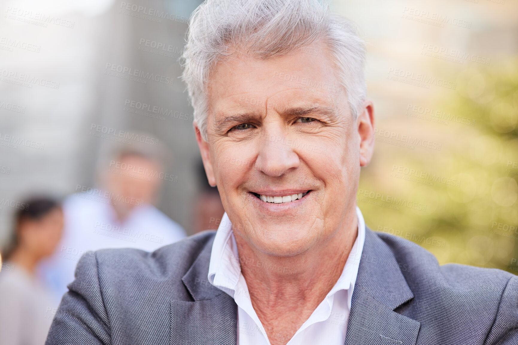 Buy stock photo Shot of a mature businessman standing outside while his colleagues stand behind him