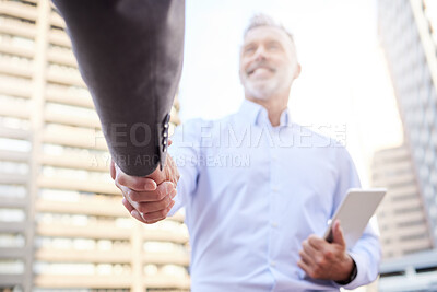Buy stock photo Shot of two businessmen standing outside on the balcony together and shaking hands