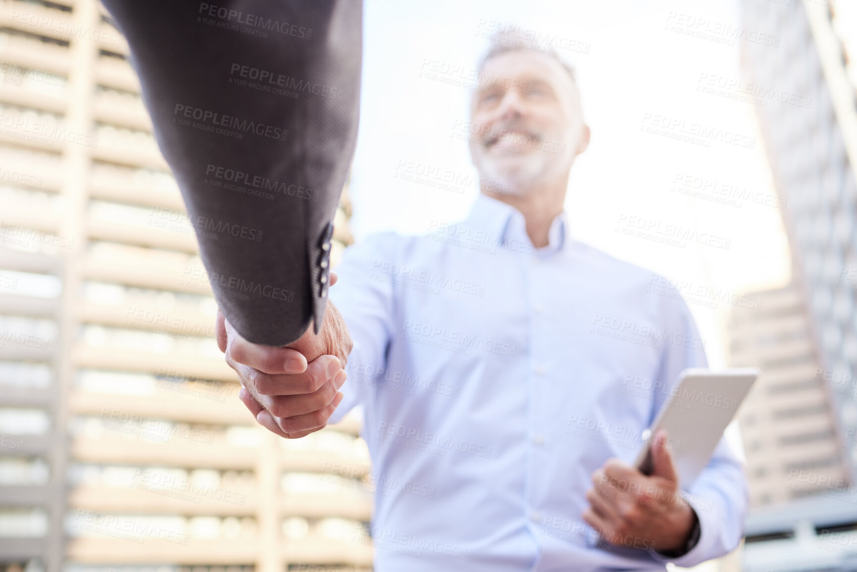 Buy stock photo Shot of two businessmen standing outside on the balcony together and shaking hands