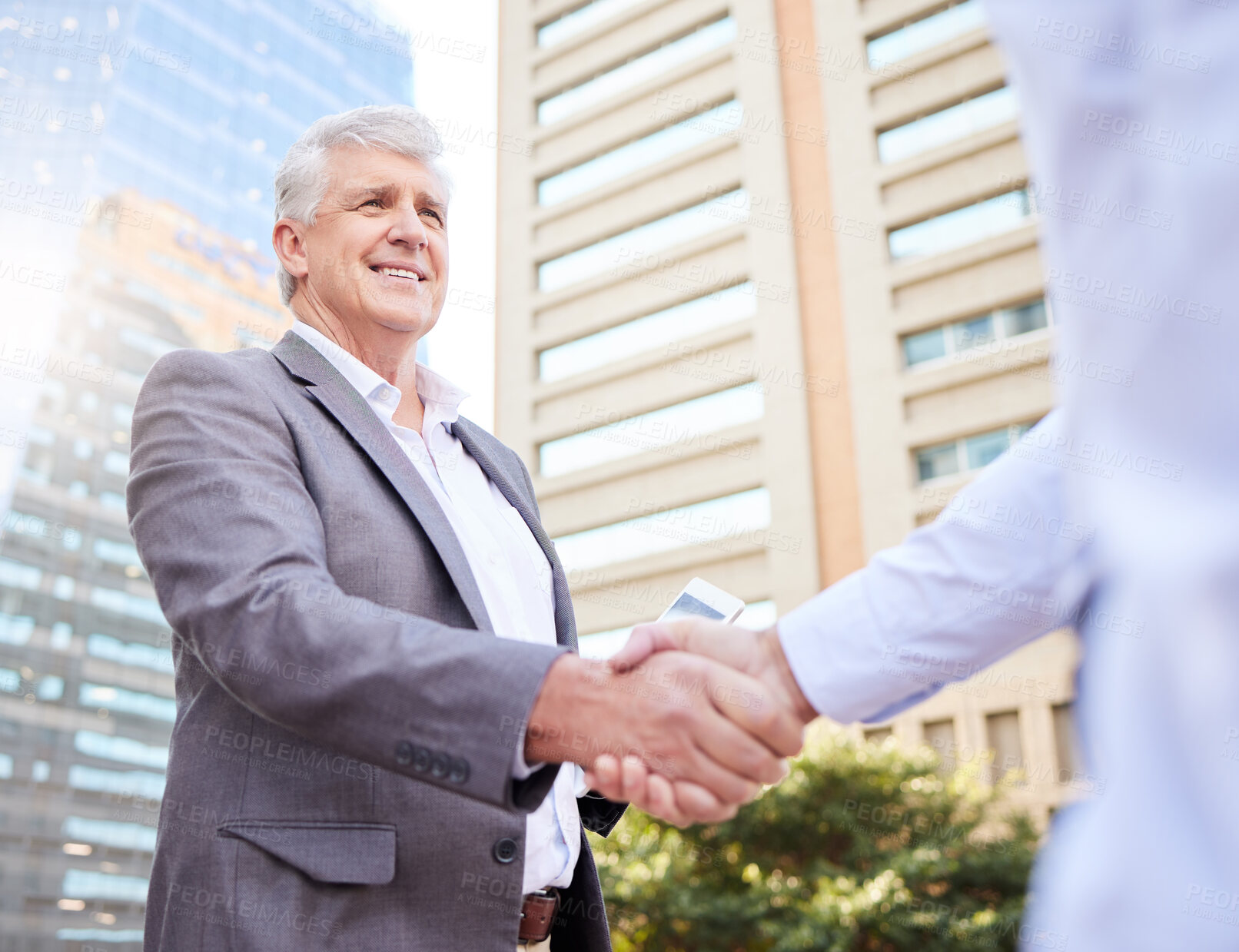 Buy stock photo Shot of two businessmen standing outside on the balcony together and shaking hands