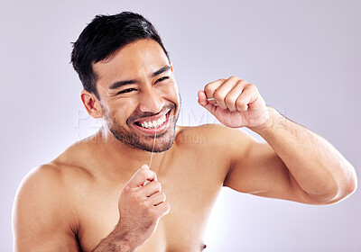 Buy stock photo Studio shot of a young man flossing his teeth