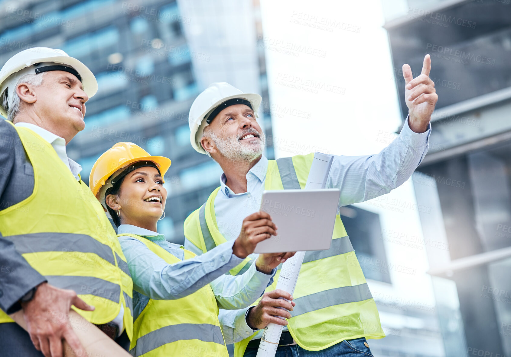 Buy stock photo Shot of a group of businesspeople using a digital tablet while working at a construction site