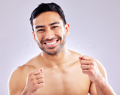 Buy stock photo Studio shot of a young man flossing his teeth