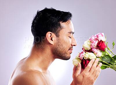 Buy stock photo Studio shot of a handsome young man posing with a bunch of roses