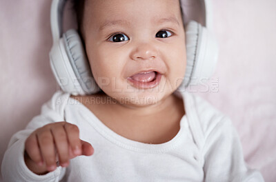 Buy stock photo High angle shot of an adorable baby wearing headphones at home