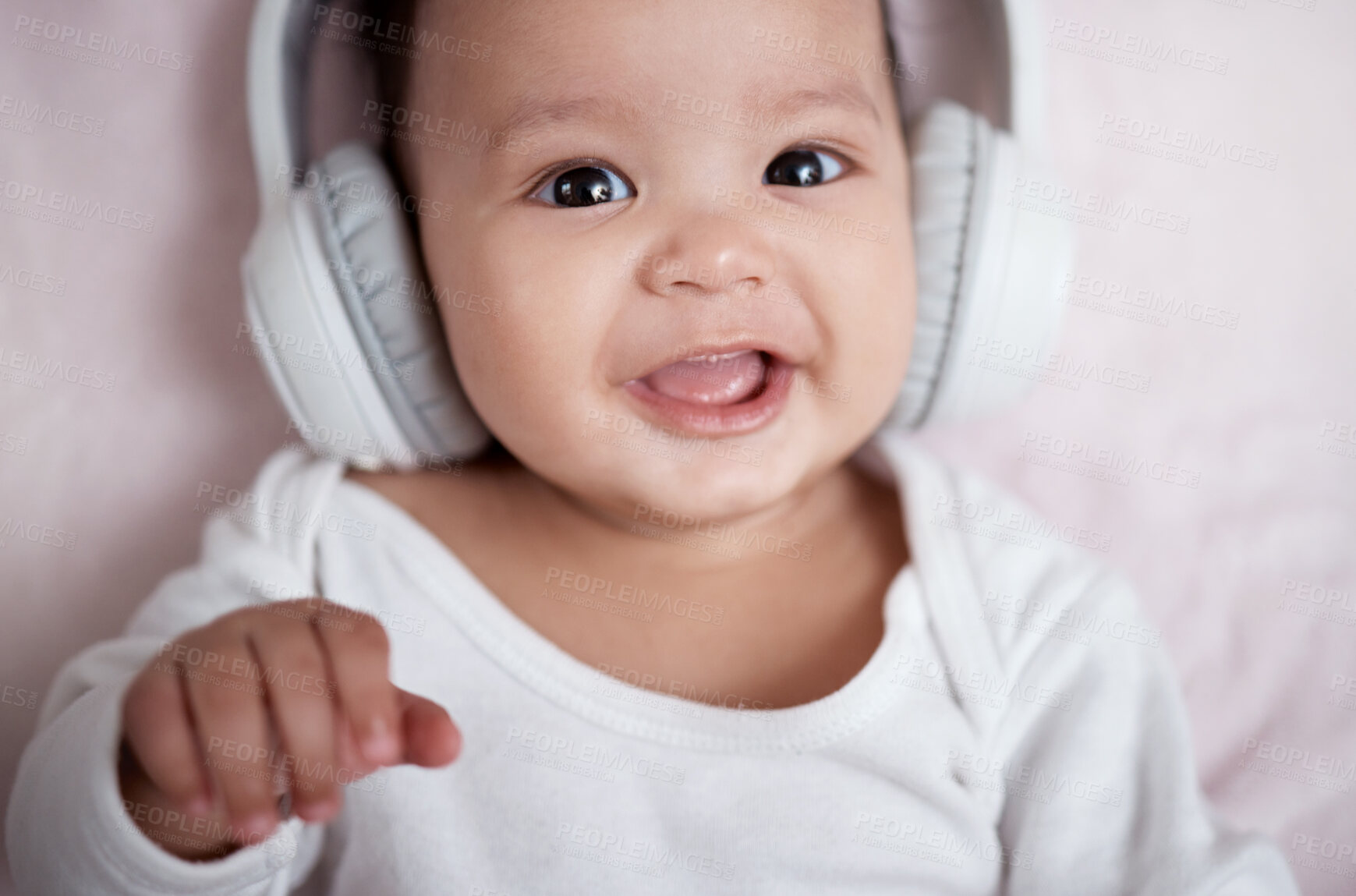 Buy stock photo High angle shot of an adorable baby wearing headphones at home