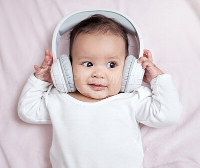 Buy stock photo High angle shot of an adorable baby wearing headphones at home