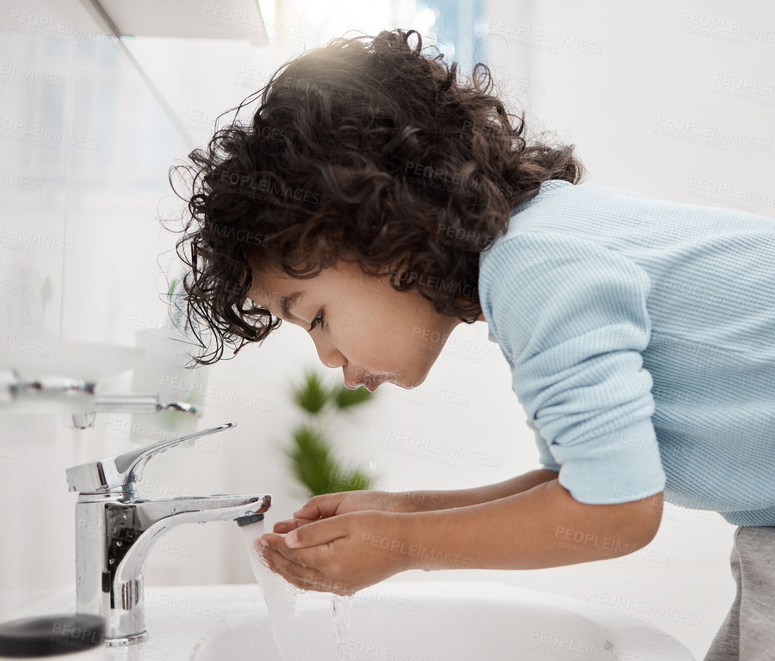 Buy stock photo Shot of an adorable little boy washing his hands and mouth at a tap in a bathroom at home