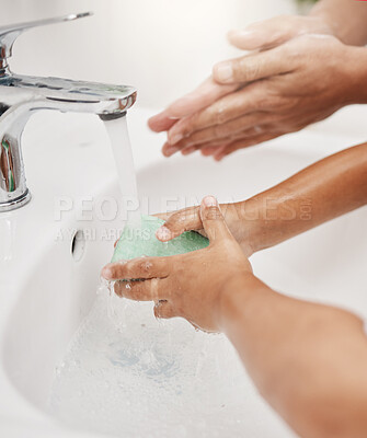 Buy stock photo Closeup shot of a father helping his son wash his hands at a tap in a bathroom at home