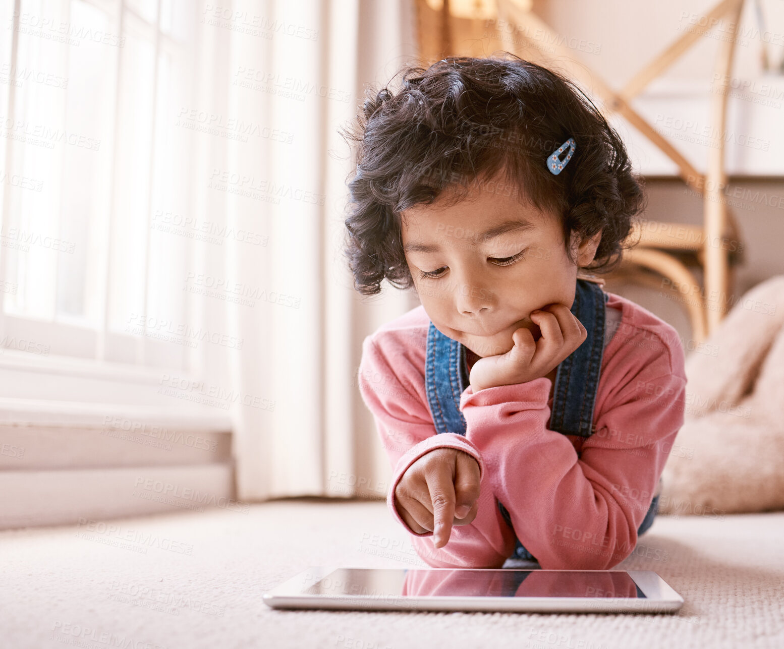 Buy stock photo Shot of a little girl using a digital tablet at home