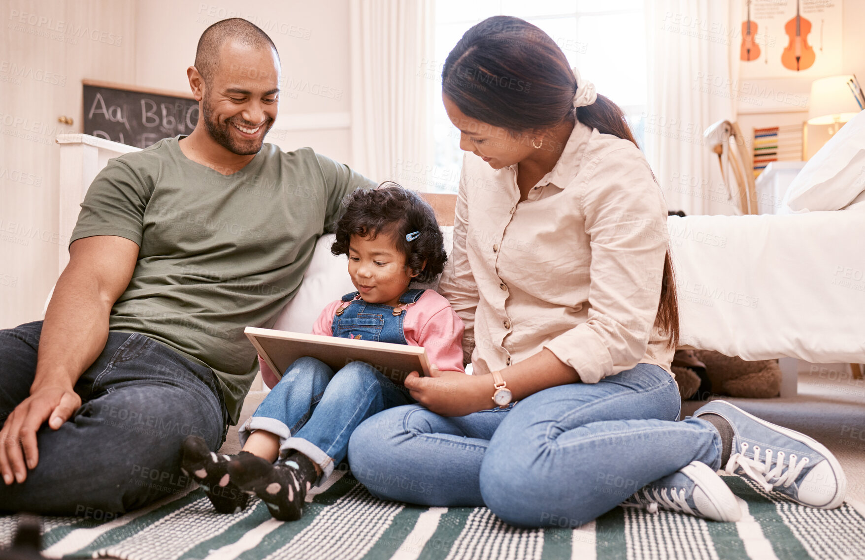 Buy stock photo Shot of a young family using a digital tablet at home