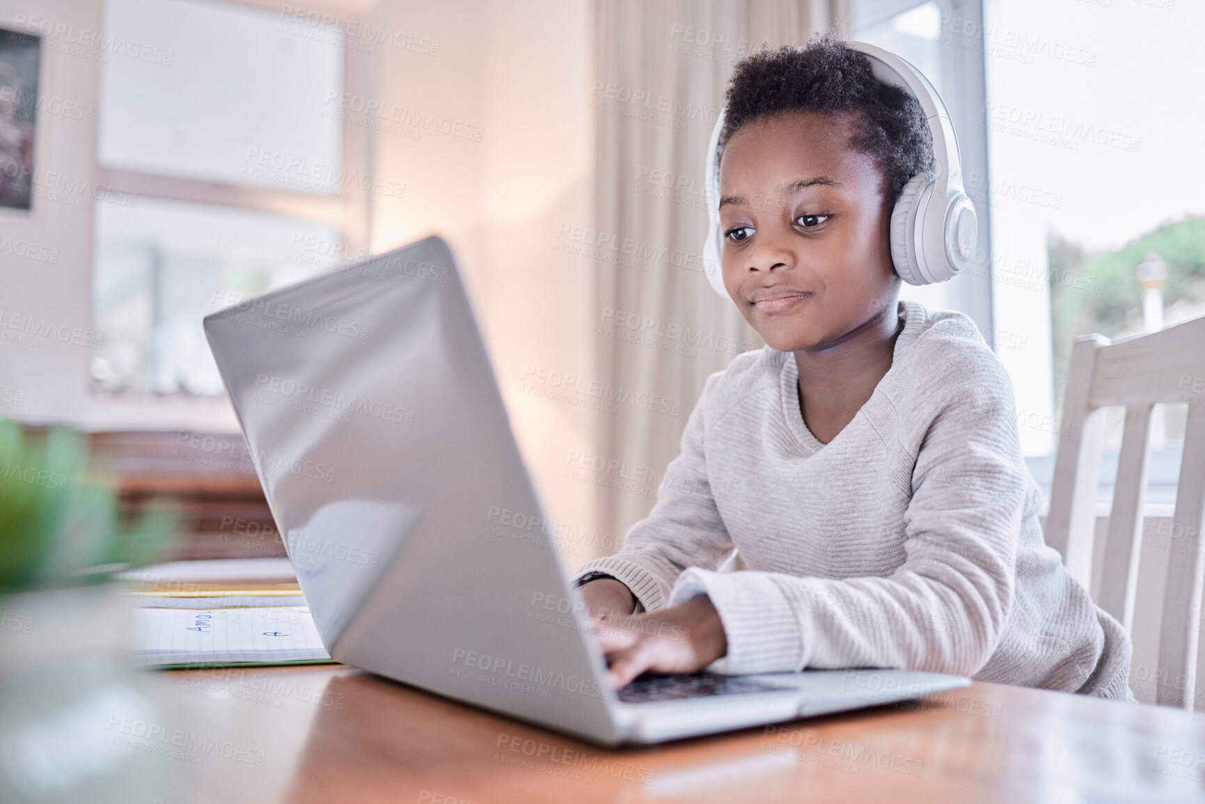 Buy stock photo Shot of a young boy doing his homework on a laptop at home