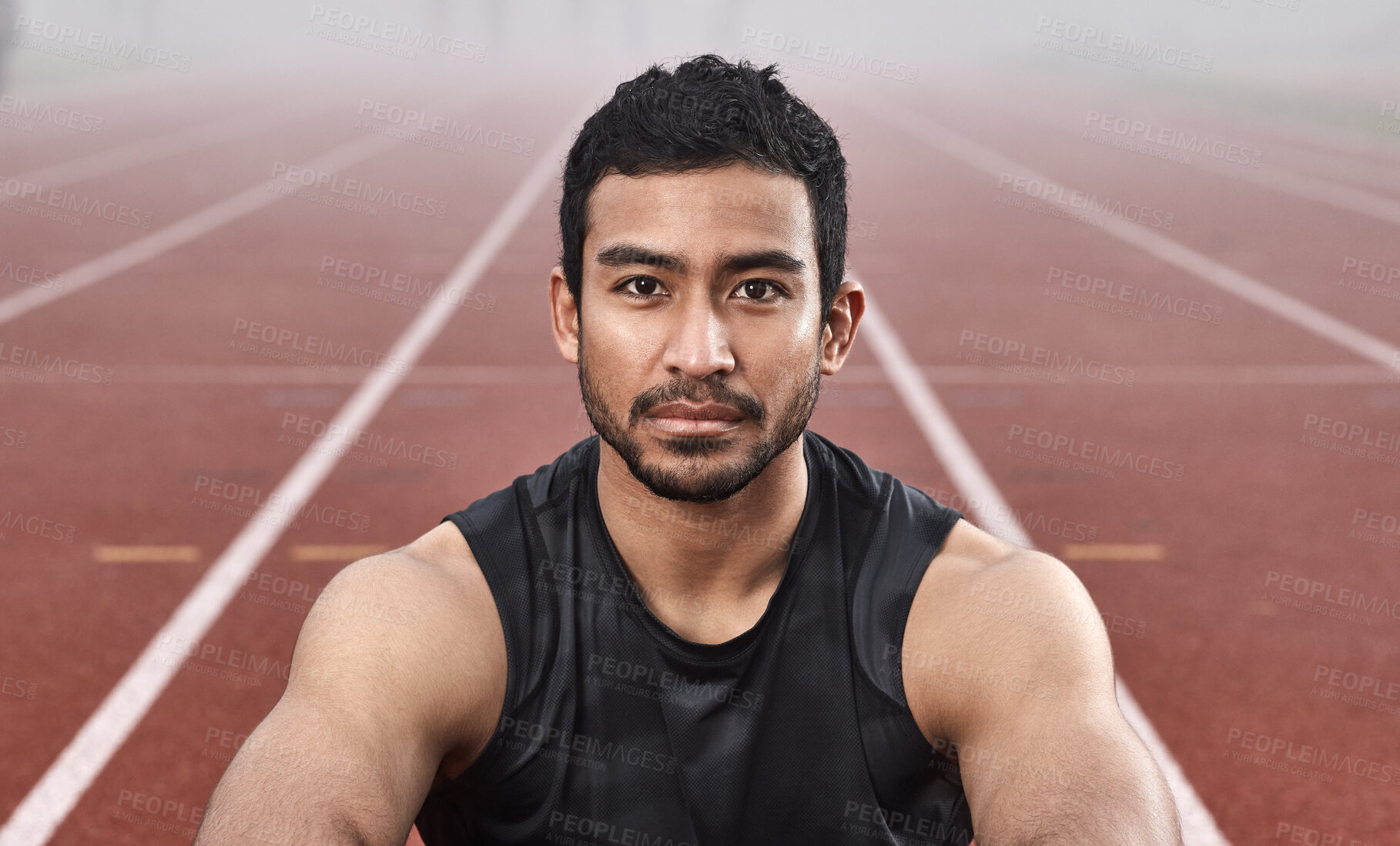 Buy stock photo Shot of a young male athlete sitting on the track before a race