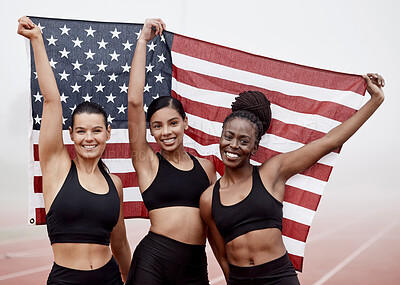 Buy stock photo Shot of female athletes celebrating their win while holding a flag