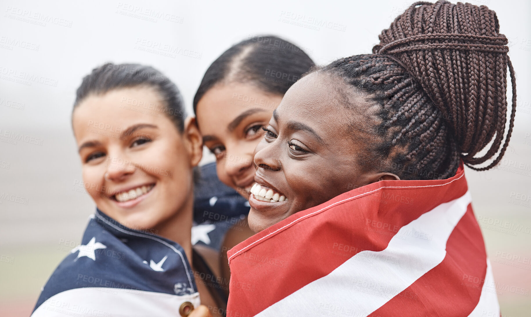 Buy stock photo Shot of female athletes celebrating their win while holding a flag