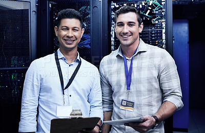 Buy stock photo Shot of two young men working together in a server room