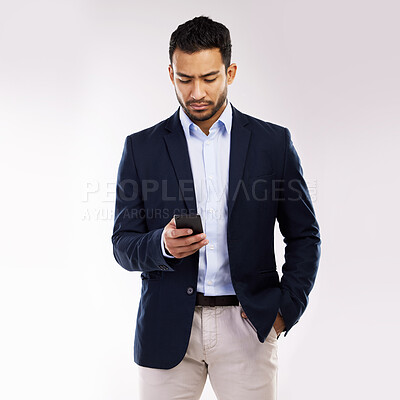 Buy stock photo Studio shot of a young businessman using a cellphone against a white background
