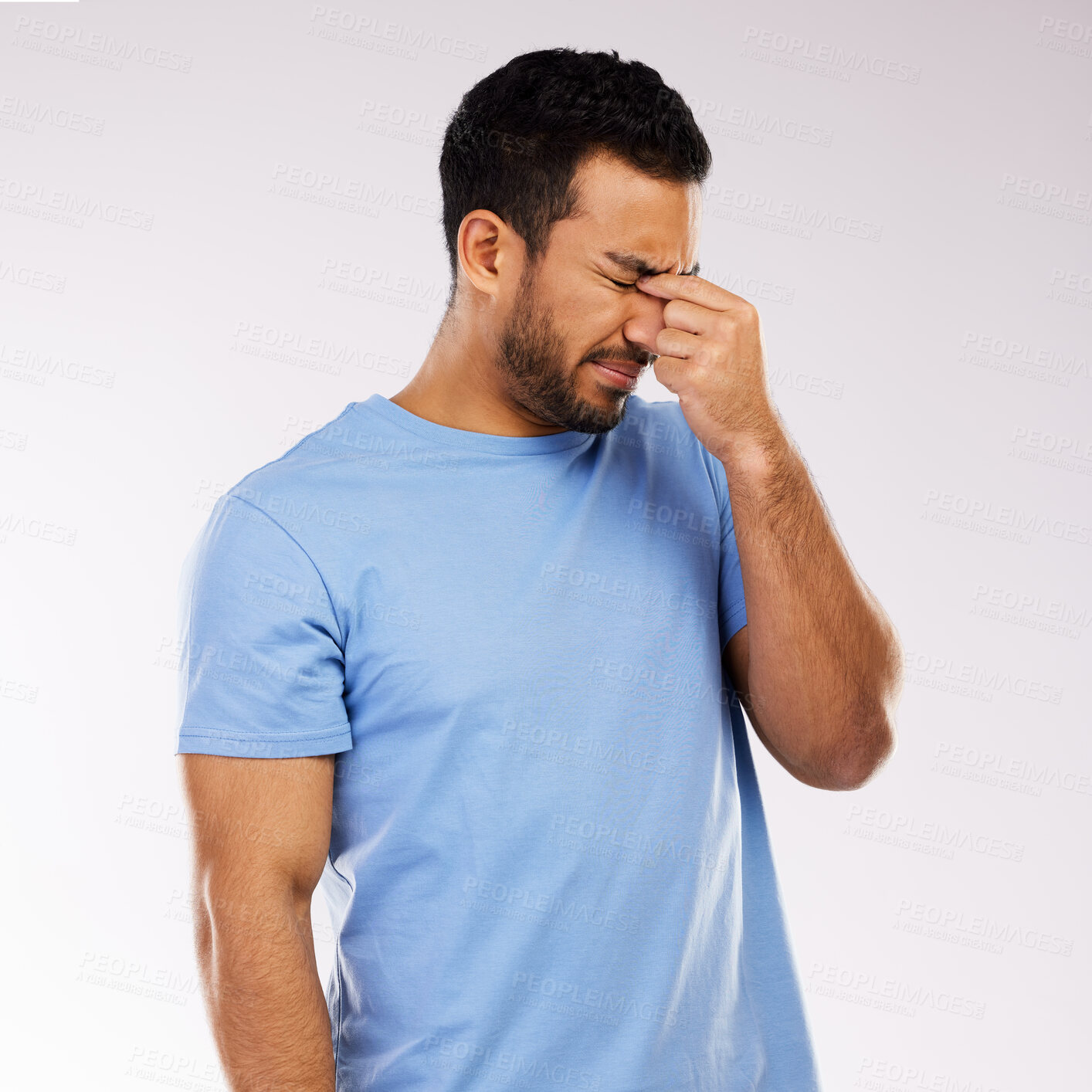 Buy stock photo Shot of a handsome man standing alone against a grey background in the studio and feeling stressed