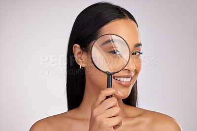Buy stock photo Studio portrait of an attractive young woman looking through a magnifying glass against a pink background