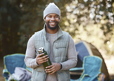 Buy stock photo Shot of a young man holding his drink flask during a camping trip