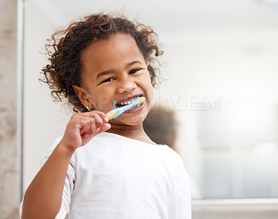 Buy stock photo Portrait of an adorable little girl brushing her teeth in a bathroom at home