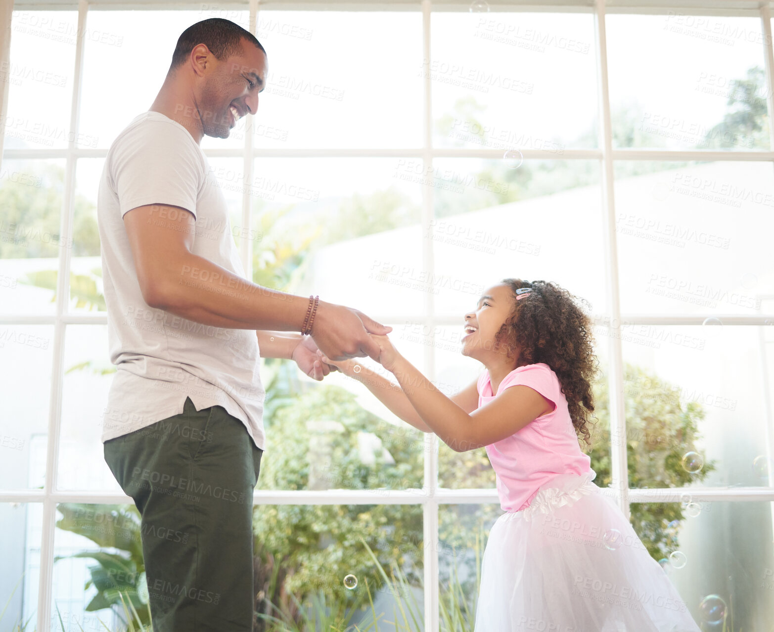 Buy stock photo Father, girl and holding hands for dancing in home, bonding and game for fun or love in childhood. Daddy, daughter and playing with child together in living room, happiness and weekend for motion