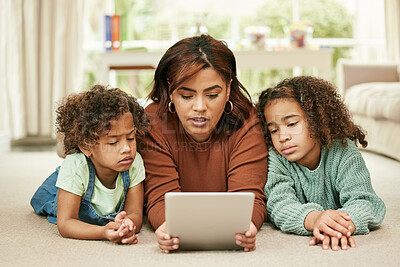 Buy stock photo Shot of a young mother and her daughters using a digital tablet at home