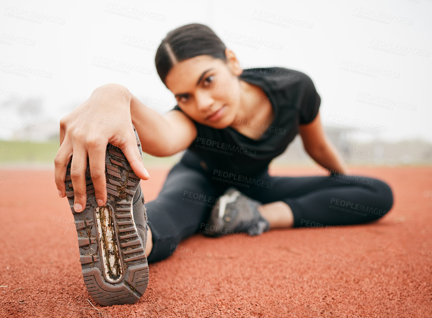 Buy stock photo Woman, portrait and stretching leg at arena, runner and training in outdoor for fitness at stadium. Female person, warm up and flexibility for muscle or athlete for cardio, getting ready and track