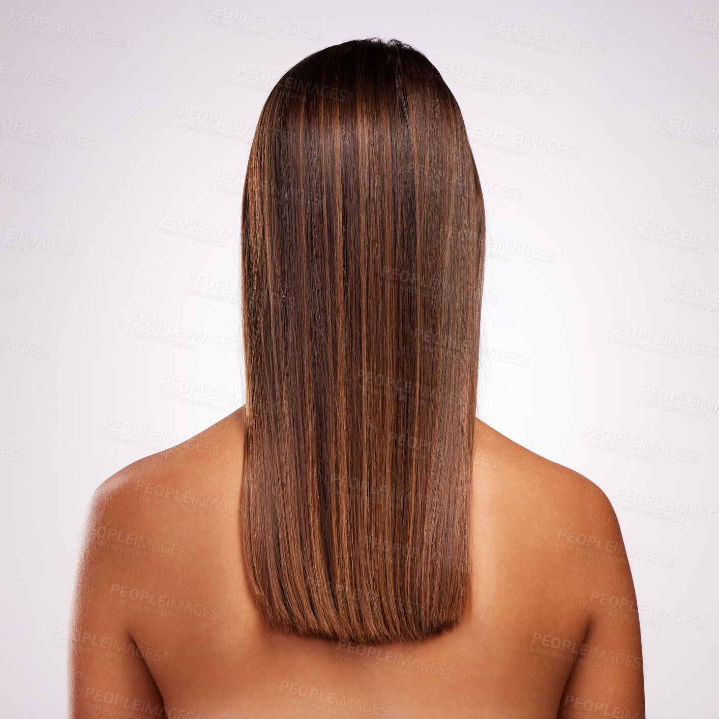 Buy stock photo Studio shot of an unrecognizable young woman standing with her back facing the camera to show off her hair against a grey background