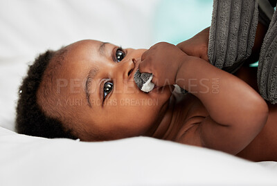 Buy stock photo Shot of an adorable little boy lying on a bed