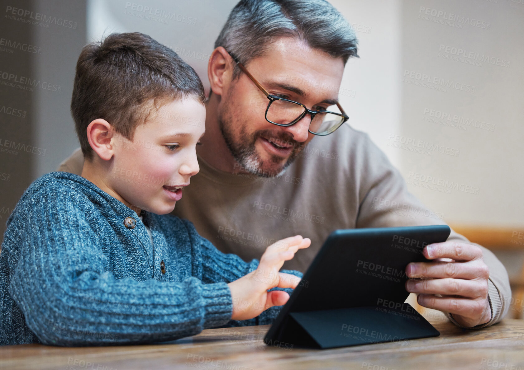 Buy stock photo Shot of a father and son using a digital tablet together