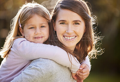 Buy stock photo Cropped portrait of an attractive young woman and her daughter posing outside in the garden at home
