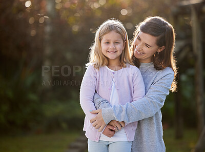 Buy stock photo Cropped shot of an attractive young woman and her daughter posing outside in the garden at home