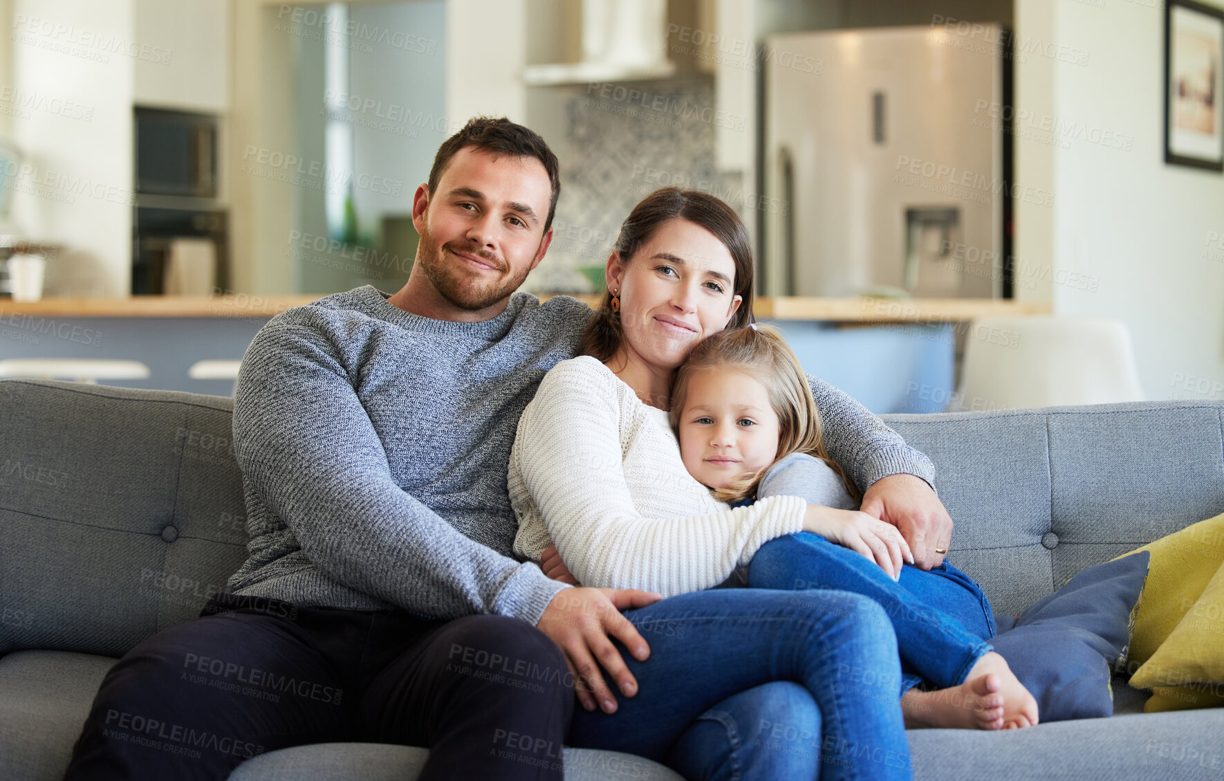 Buy stock photo Shot of a young family relaxing on the couch at home