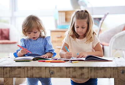 Buy stock photo Shot of two little sisters drawing at home