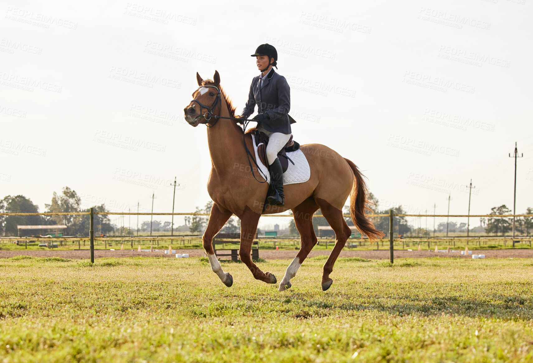 Buy stock photo Shot of a young rider jumping over a hurdle on her horse