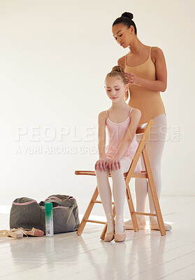Buy stock photo Shot of a ballerina helping a younger girl style her hair in a dance studio
