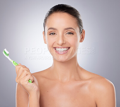 Buy stock photo Shot of a beautiful young woman brushing her teeth against a grey background