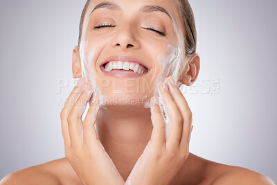 Buy stock photo Shot of a young beautiful woman washing her face against a grey background