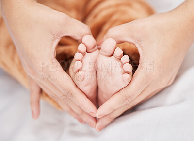 Buy stock photo Shot of a mother creating a heart shape around her baby's feet