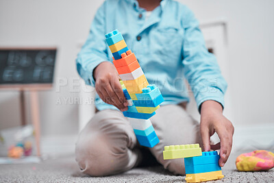 Buy stock photo Shot of a young boy playing with building blocks in a room