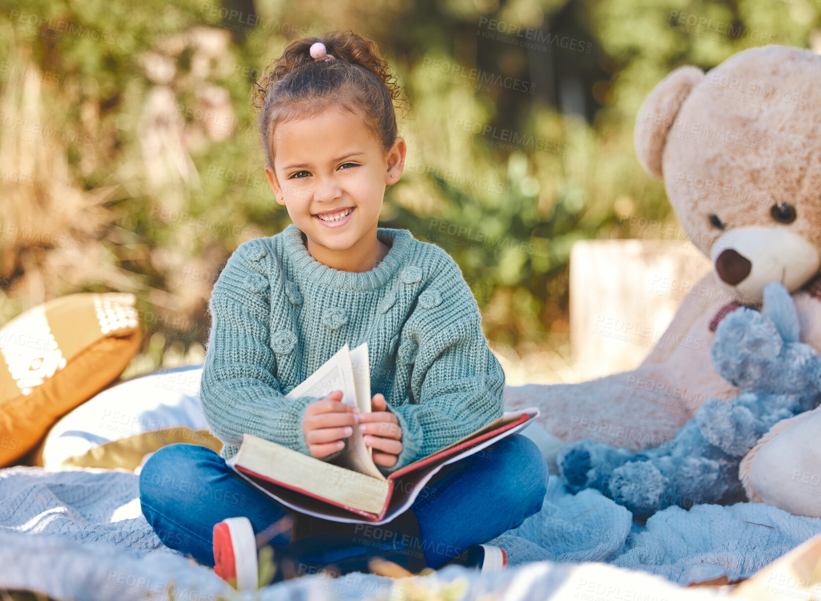 Buy stock photo Shot of a little girl reading a book during a picnic