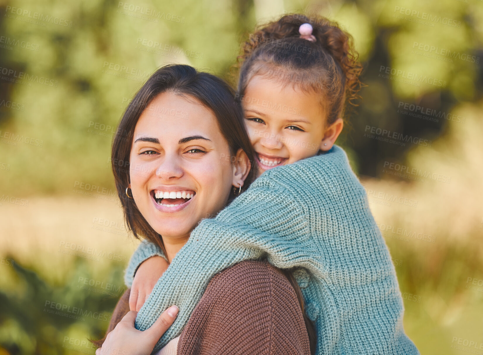 Buy stock photo Shot of a mother giving her daughter a piggyback ride during a picnic